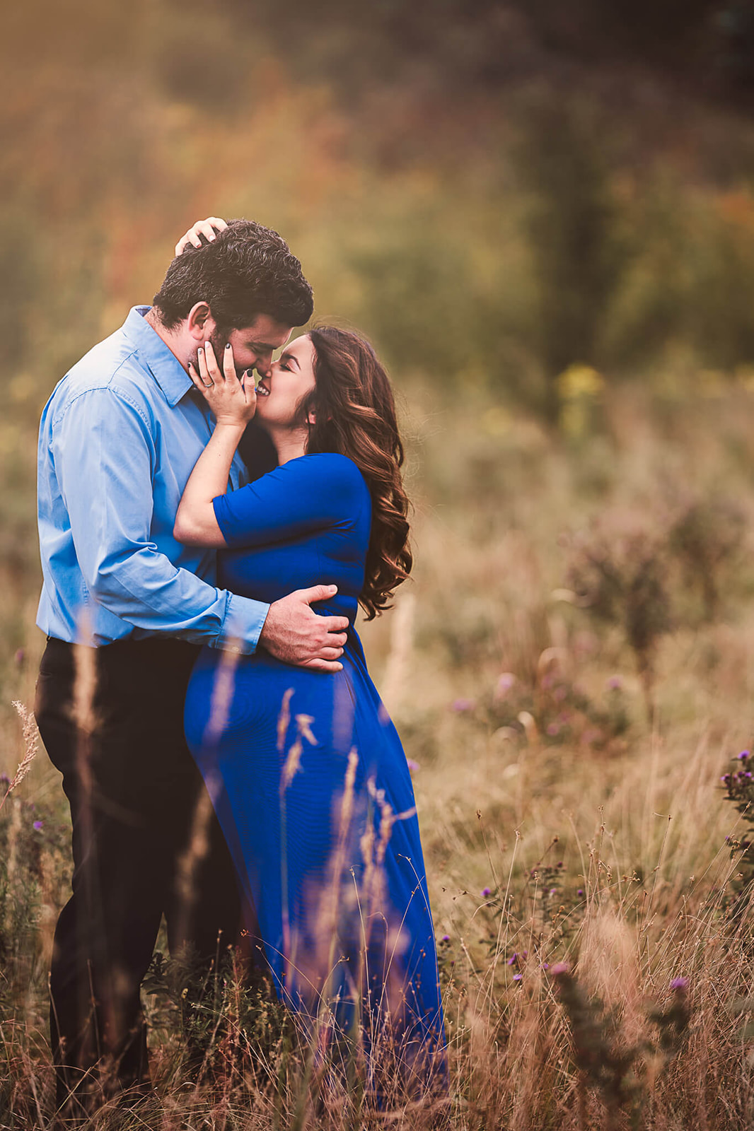pregnant couple during maternity photoshoot in grass field