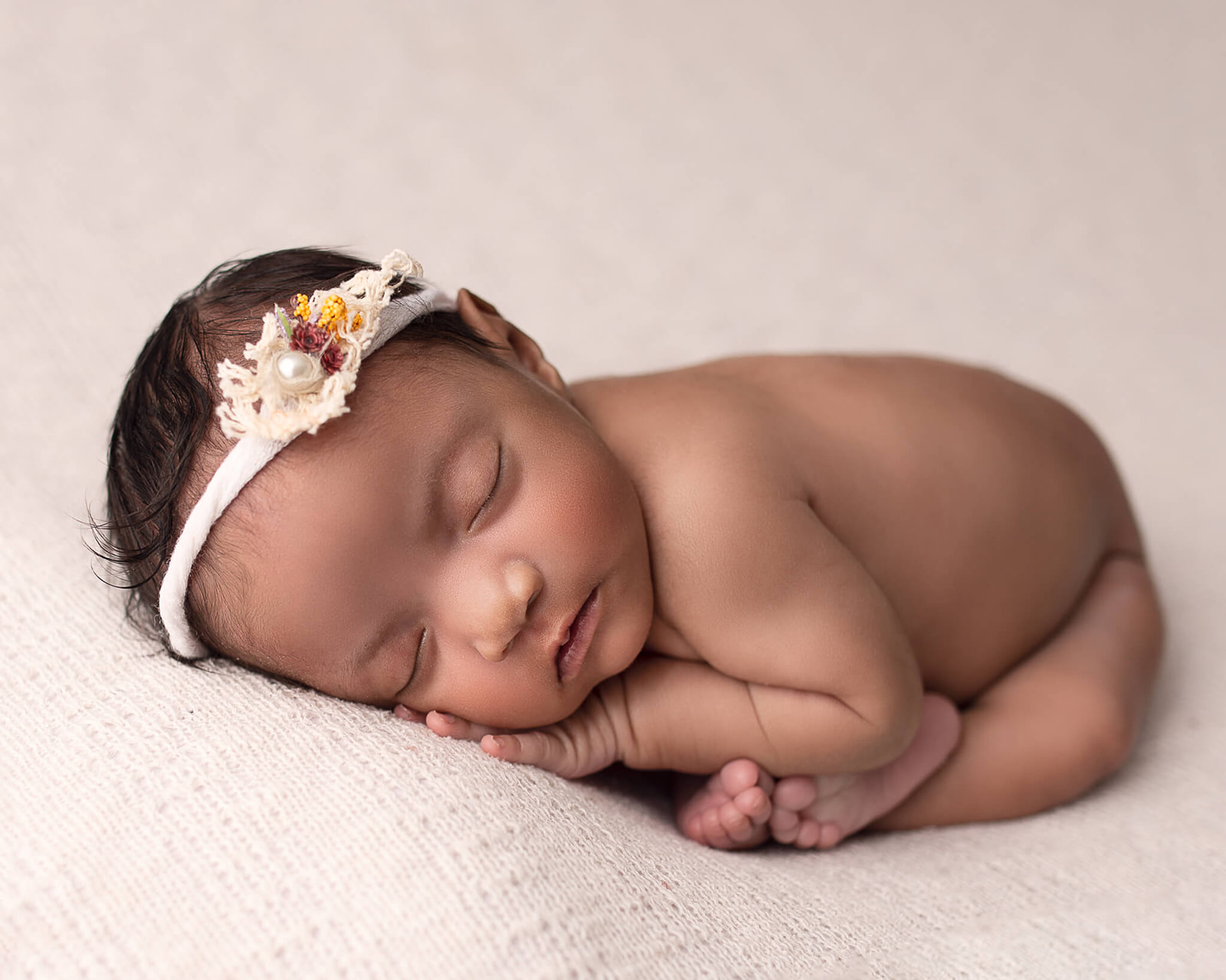 sleeping newborn in fetal position pose during newborn photography session