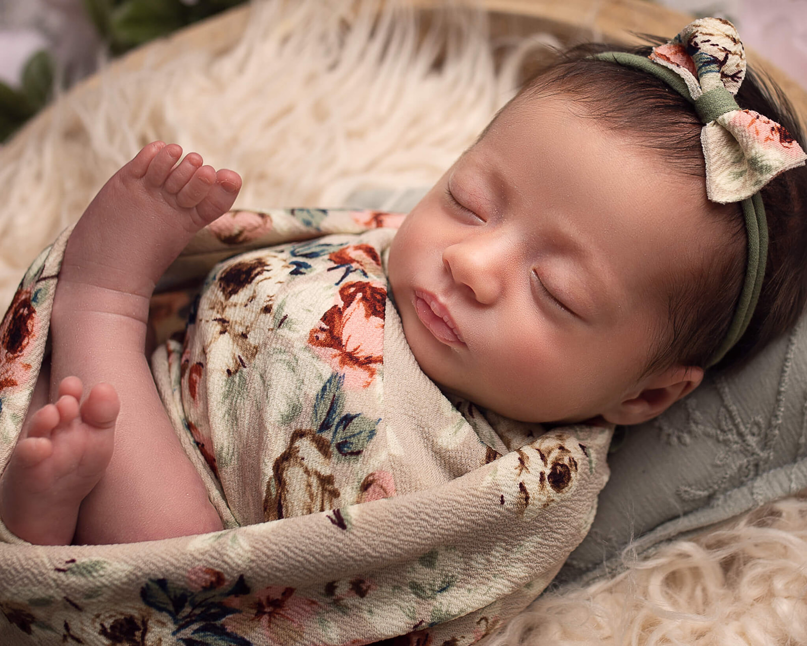Let's talk about newborn care tips! Sleeping newborn during newborn photography session with floral wrap
