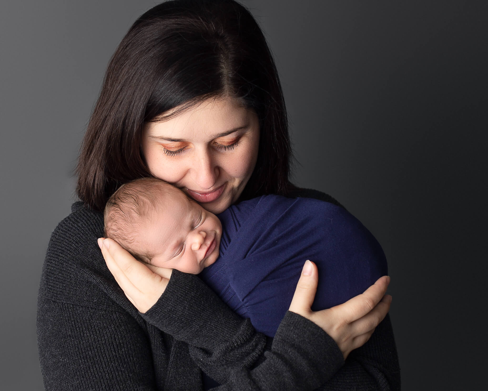 Mom and newborn wrapped in blue photo for homeopathic doctors in Akron