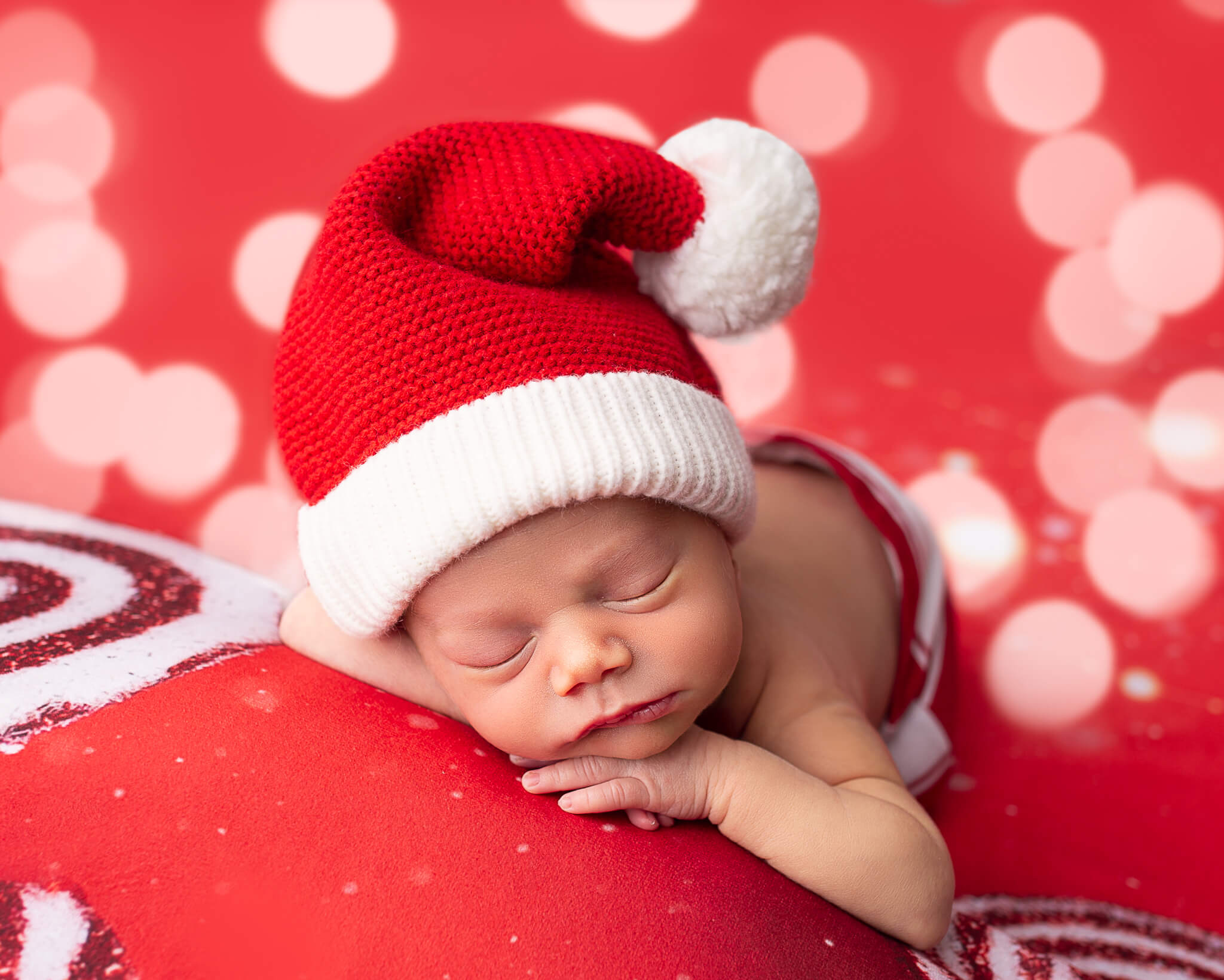 Sleeping newborn in Christmas hat for homeopathic doctors in Akron blog