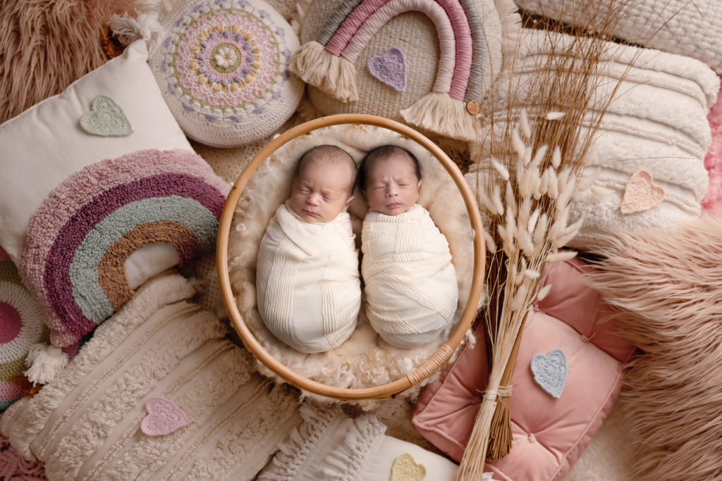 how to prevent unsafe sleep for newborns in blog photo of twins sleeping in white swaddles