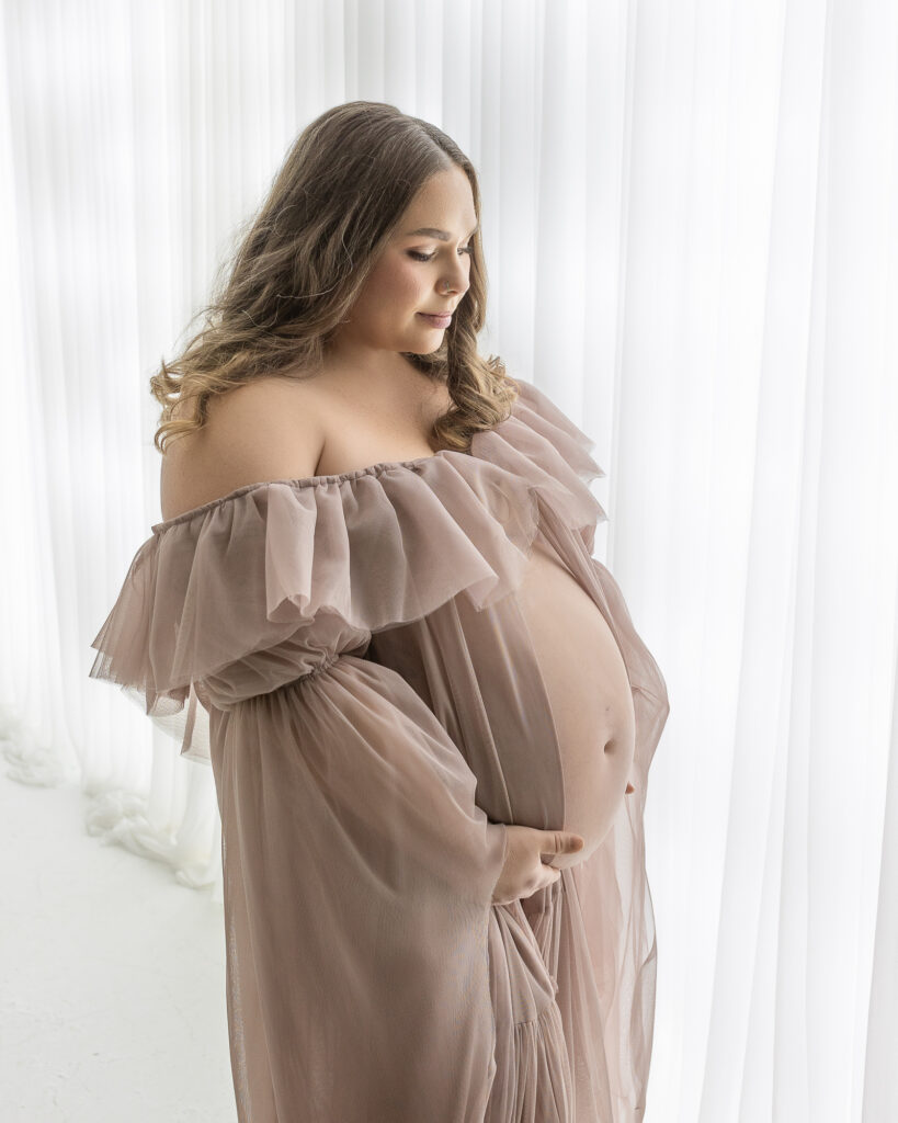 Akron Ohio maternity photographer capturing expecting mother in soft studio light during maternity session