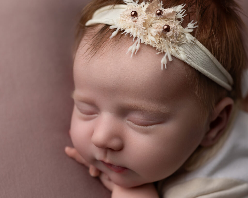 Akron newborn photography close-up portrait of a sleeping newborn wearing a delicate floral headband