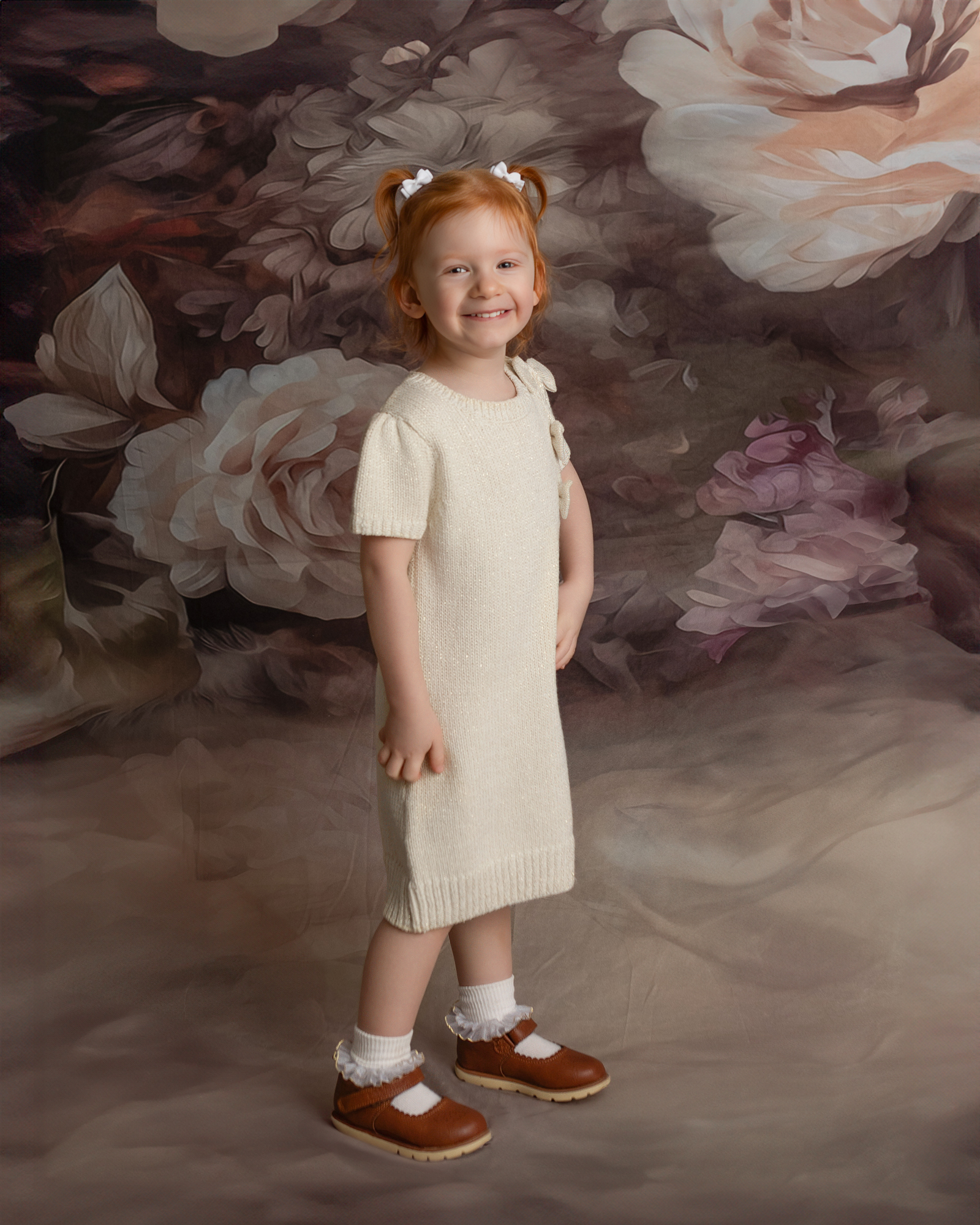 Toddler girl smiling during a milestone portrait session at a children’s photography studio, a fun activity for toddlers in Canton Ohio.
