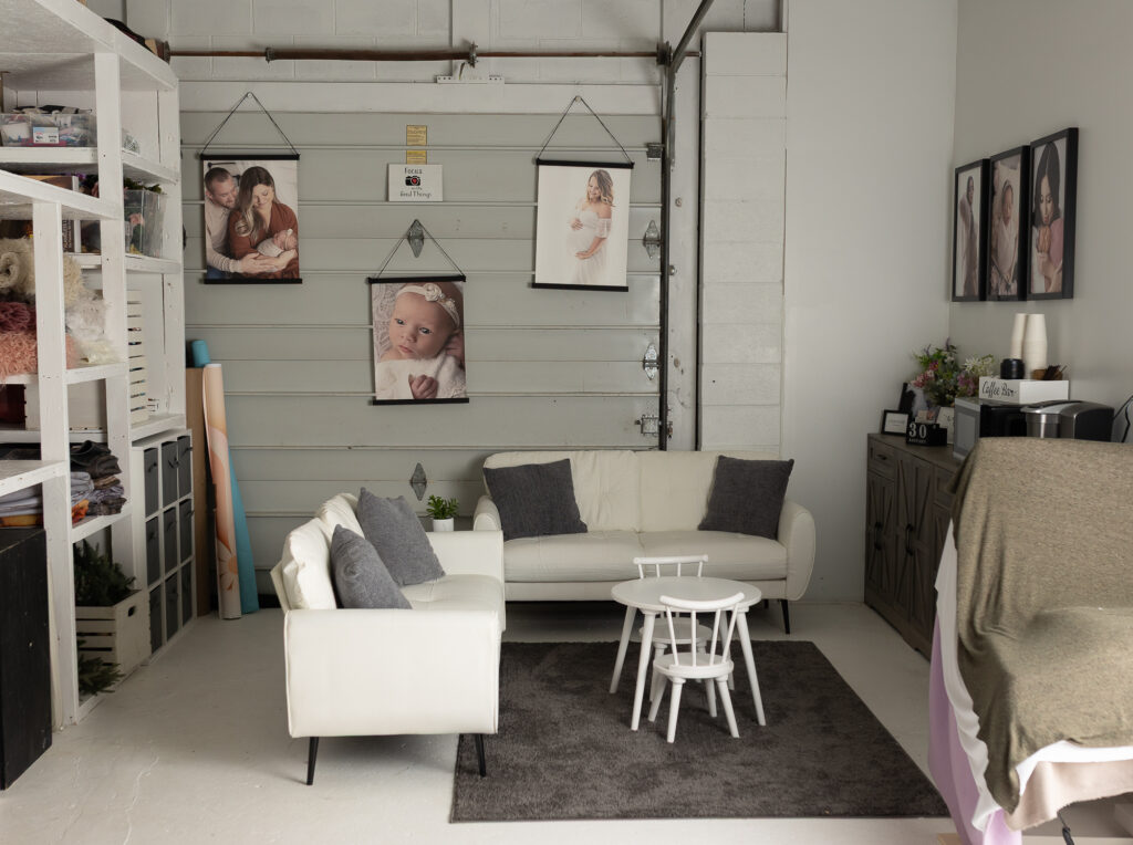 Parent lounge area inside newborn photography studio with seating, snack station, and coffee bar