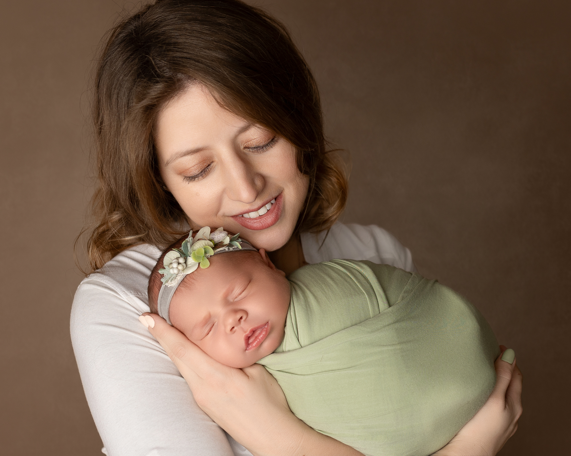 Mother holding her newborn baby at home, a moment often supported by families hiring nannies in Ohio